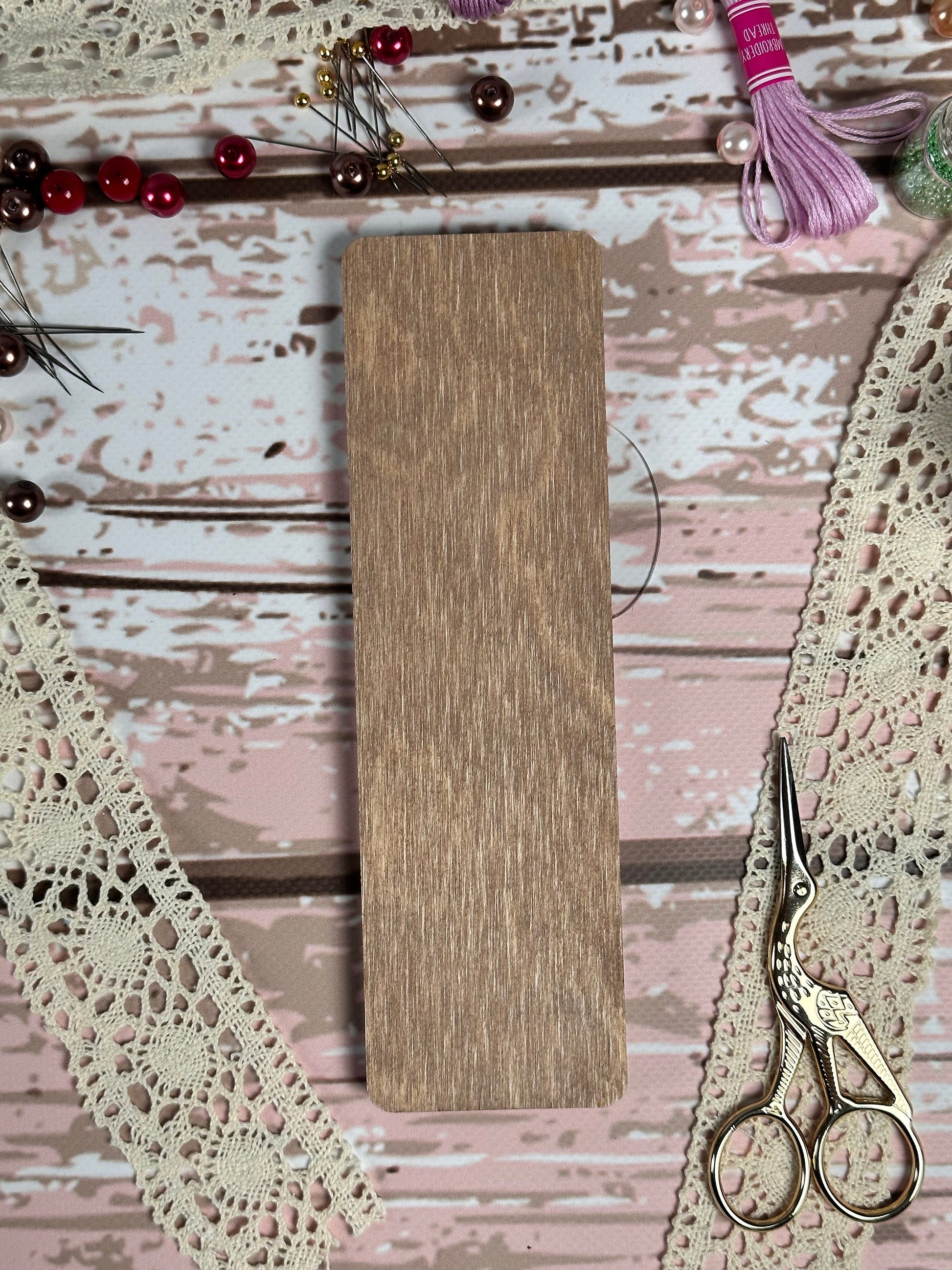 a wooden sign sitting on top of a table next to a pair of scissors