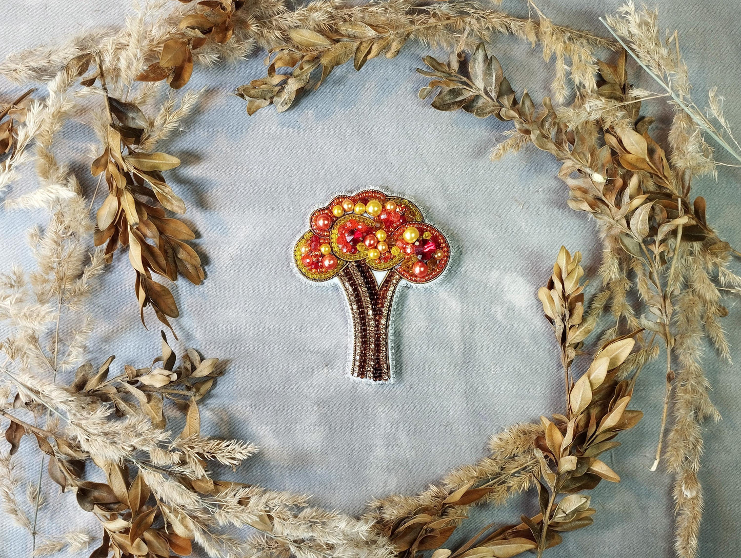 a brooch with a tree made out of apples