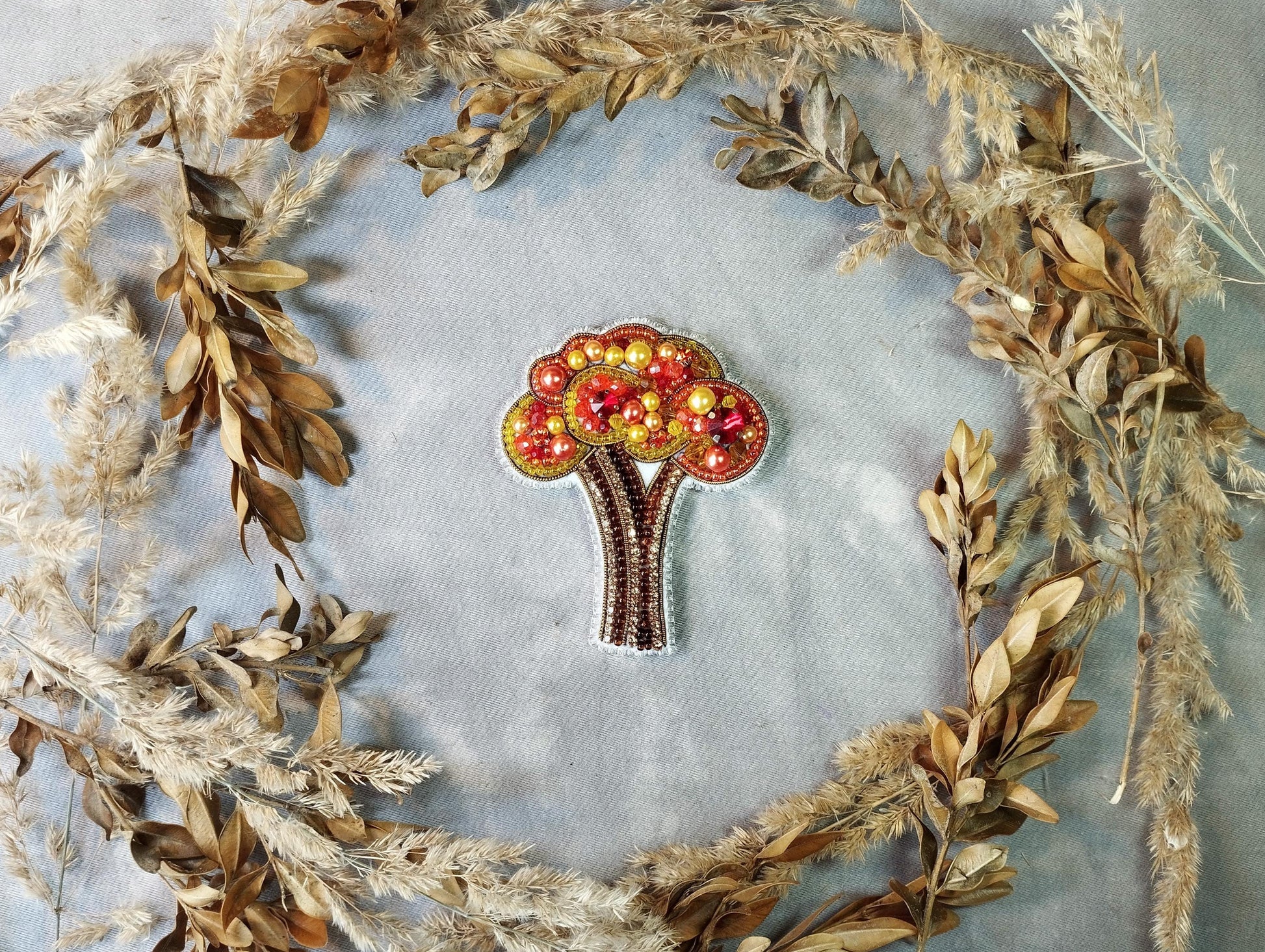 a brooch with a tree made out of apples
