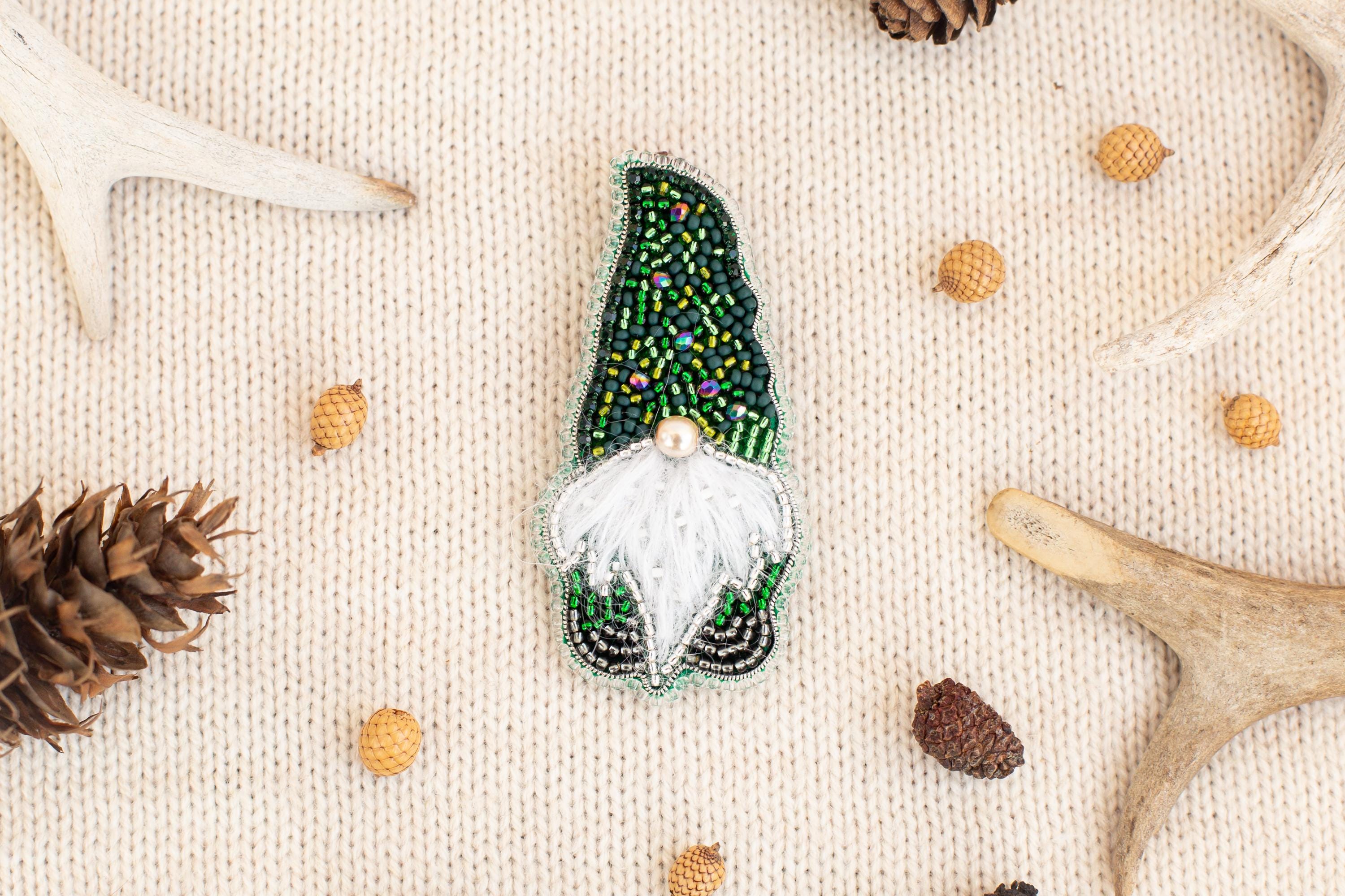 a green and white ornament resembling a gnome, surrounded by various natural elements such as pine cones, antlers, and acorns.