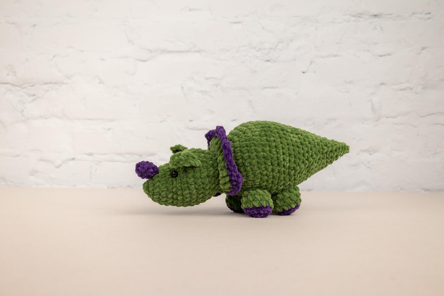 a crocheted green and purple stuffed animal