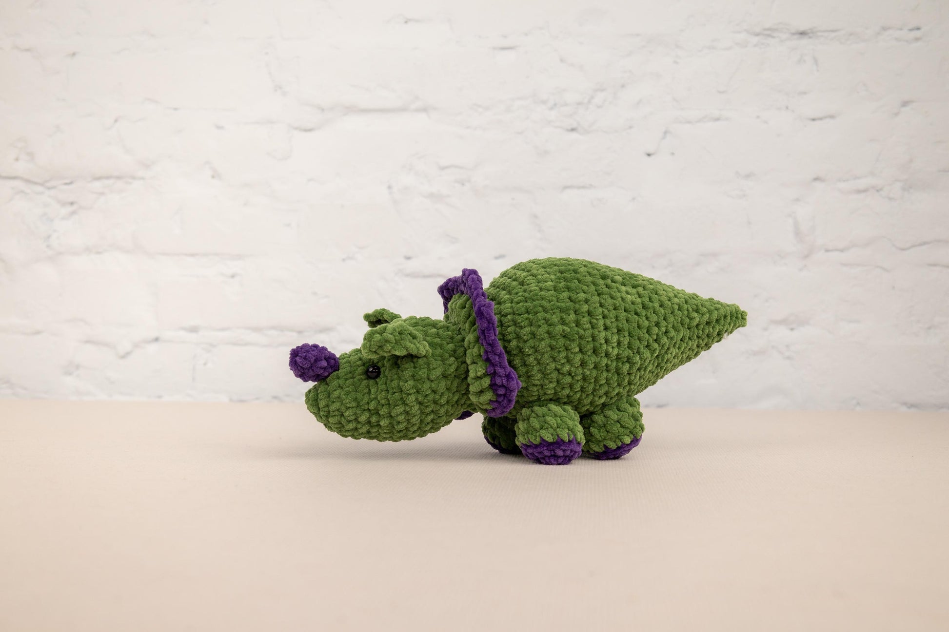 a crocheted green and purple stuffed animal