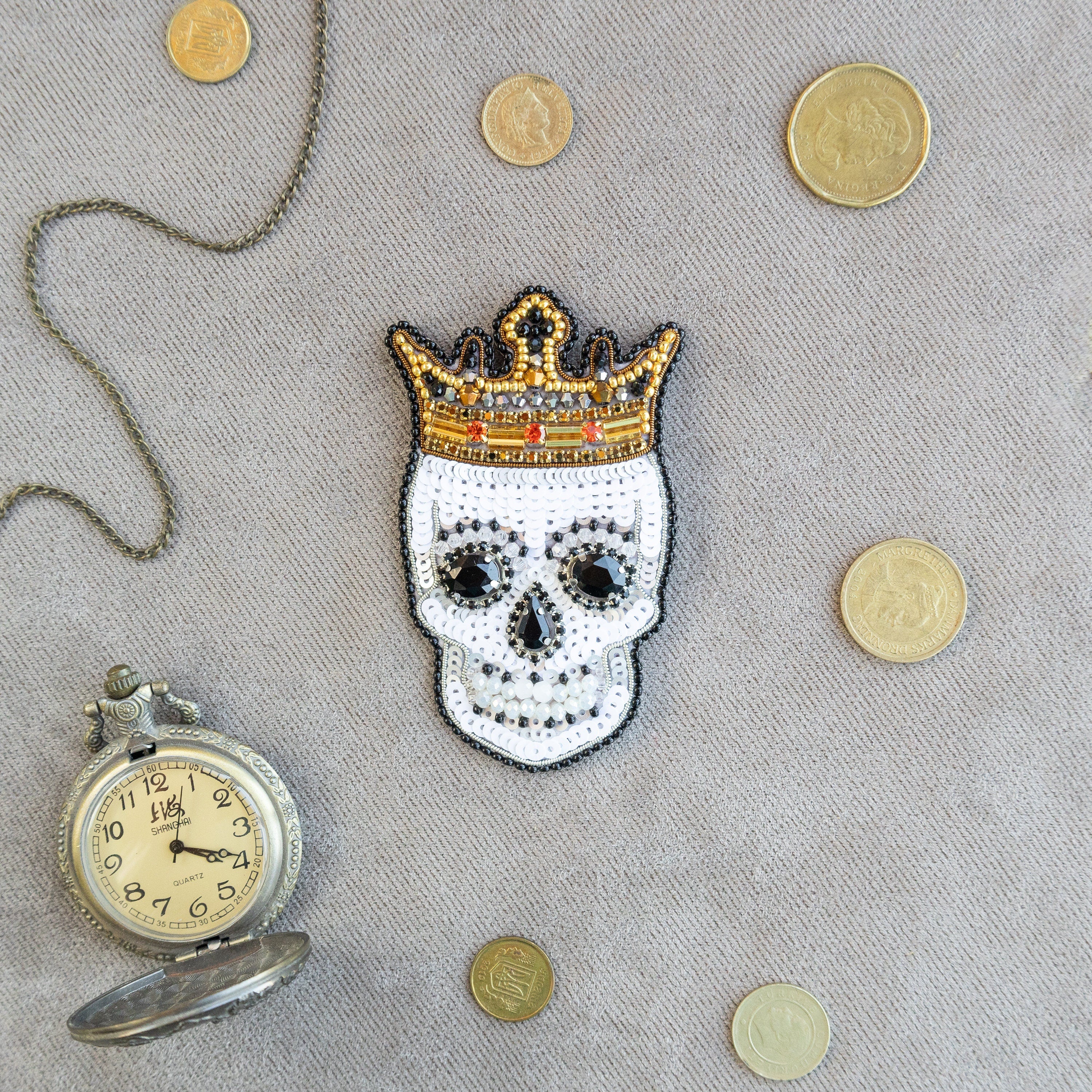 a skull with a crown next to a pocket watch