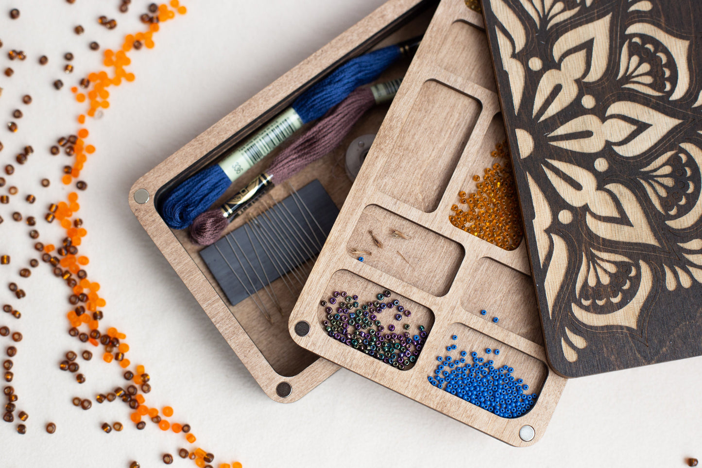 a wooden box filled with beads and thread