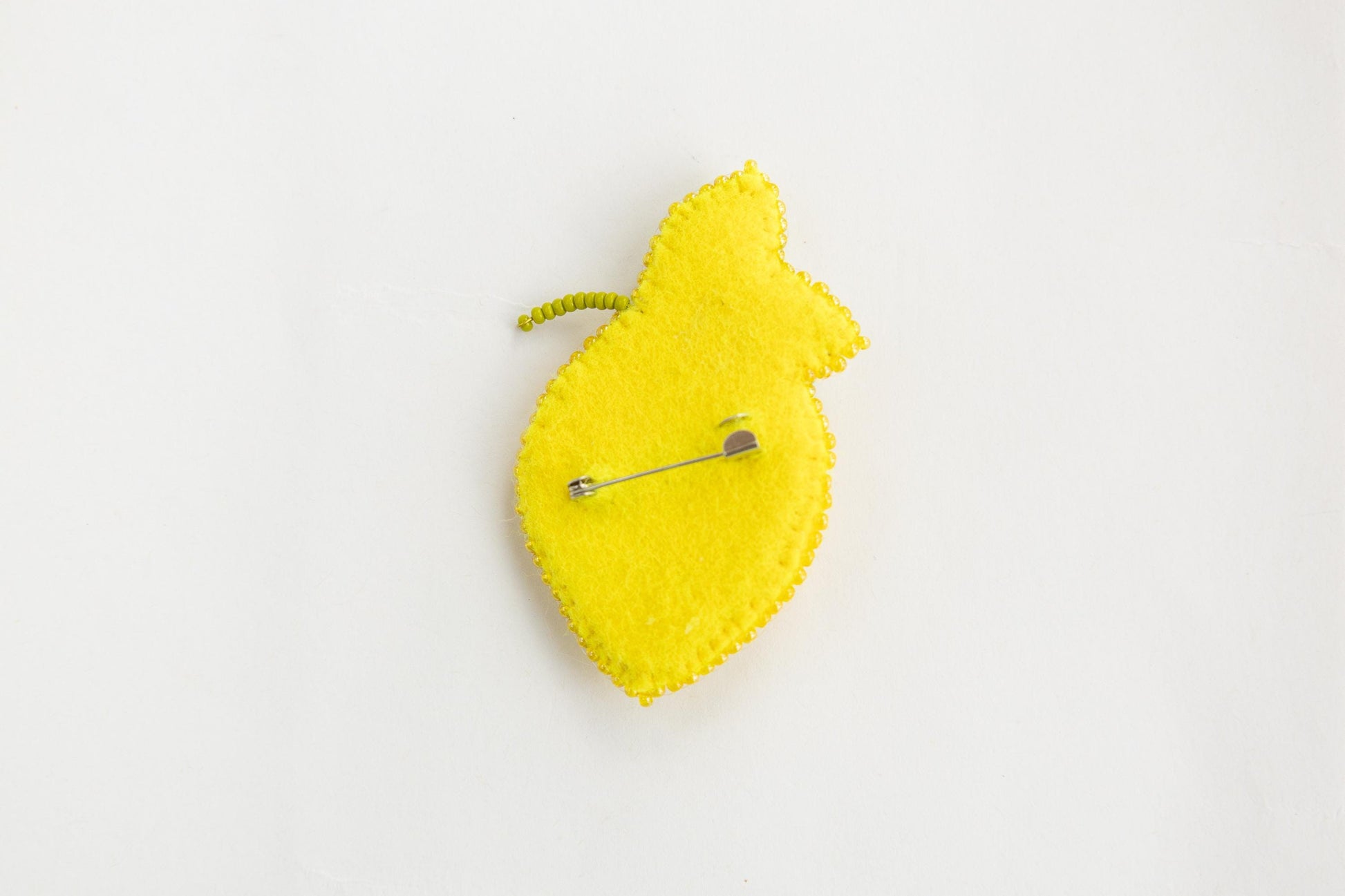 a yellow piece of felt with a pin on it