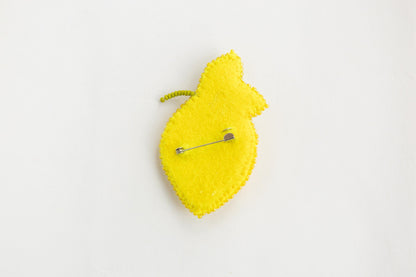 a yellow piece of felt with a pin on it