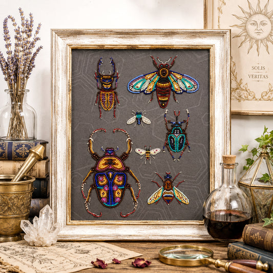 a framed collage of six colorful, intricately designed insects, including a large dragonfly, a bee, and several other insects, all set against a grey background. The insects are arranged in a visually appealing manner, with some overlapping each other and others standing out in their vibrant colors. The frame is placed on a wooden surface, surrounded by various objects such as a crystal, a vase, and a magnifying glass, creating a visually interesting and harmonious display.