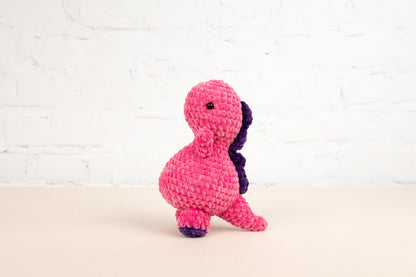 a pink and purple stuffed animal sitting on top of a table