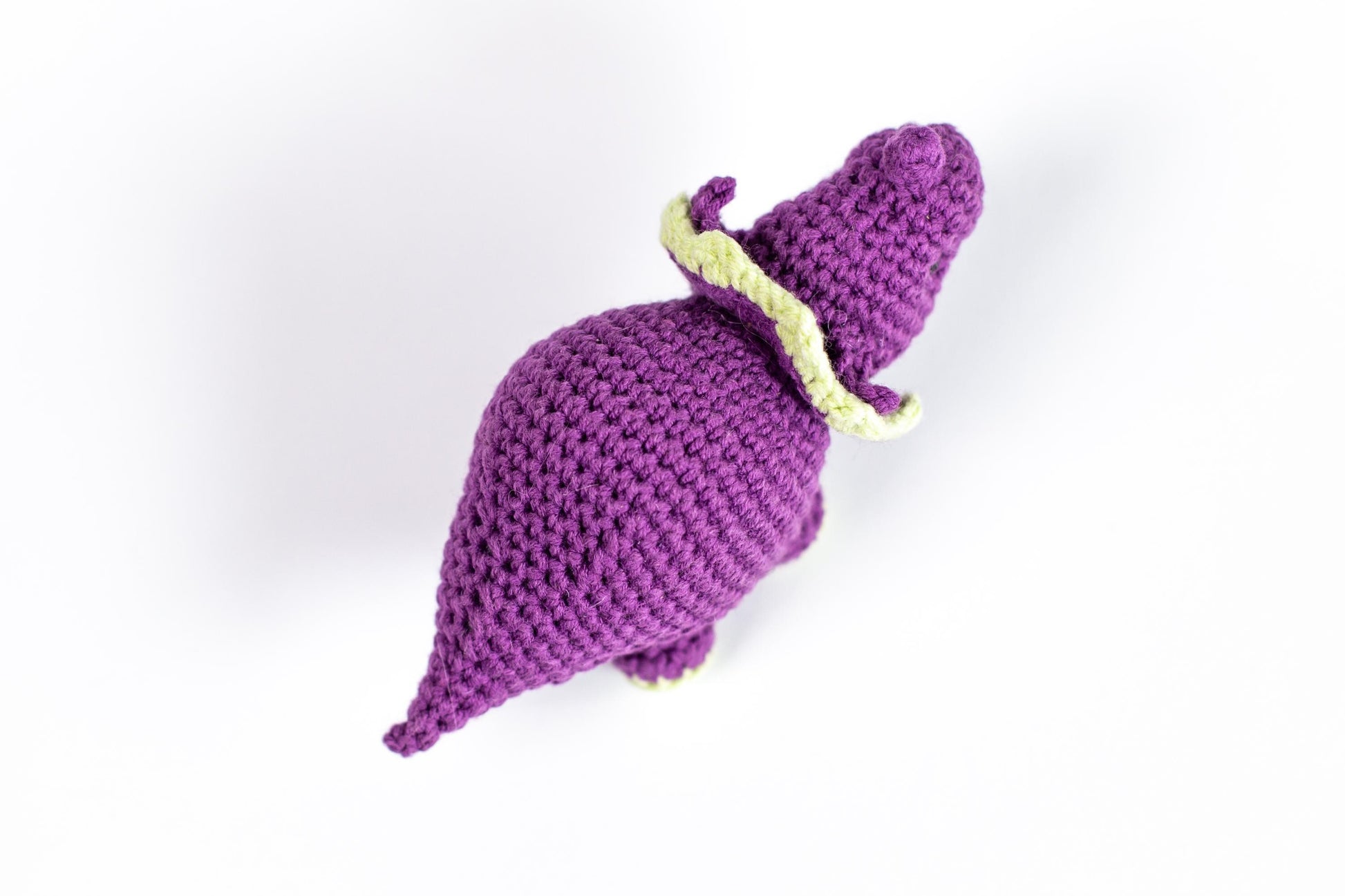 a crocheted purple elephant with a yellow tail