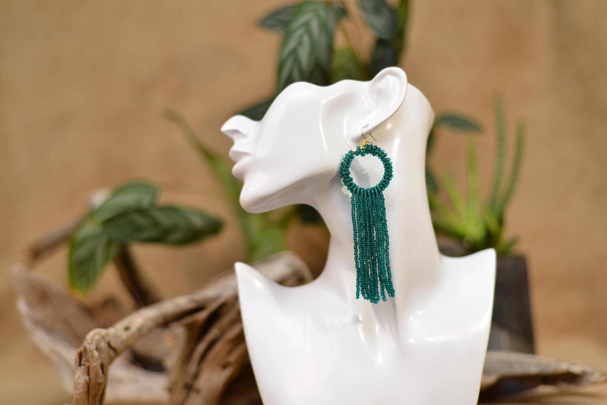 a white mannequin head with a green tassel