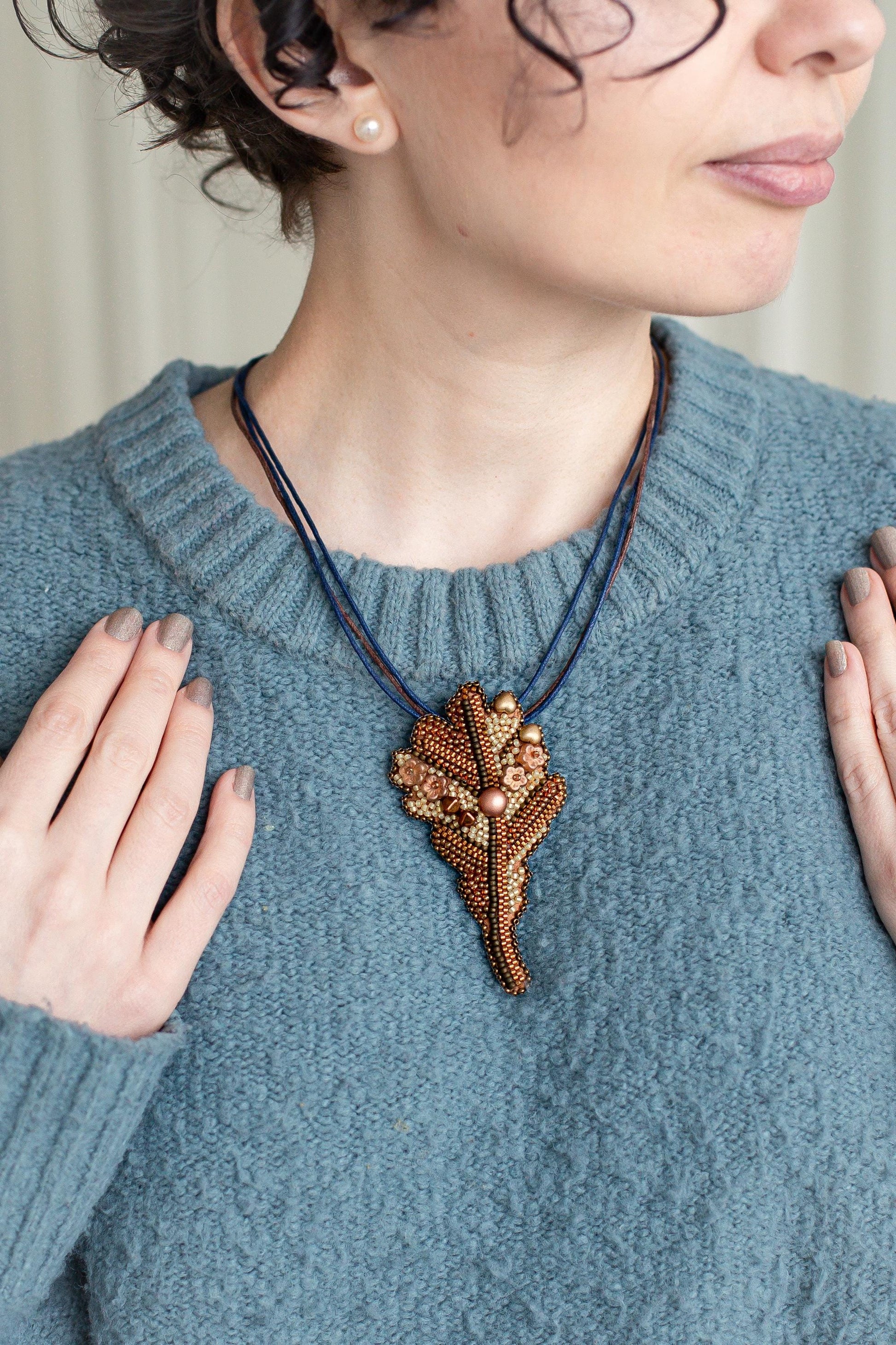 a woman wearing a blue sweater and a necklace