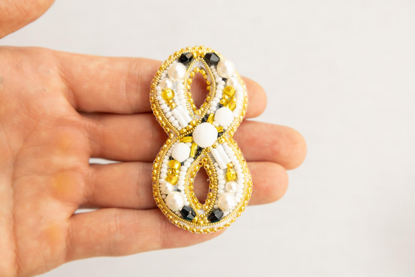 a person is holding a brooch in their hand