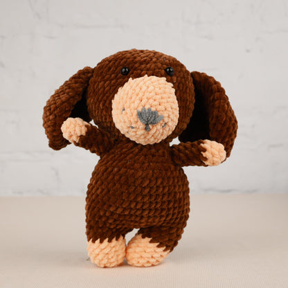 a brown stuffed animal with a white brick wall in the background