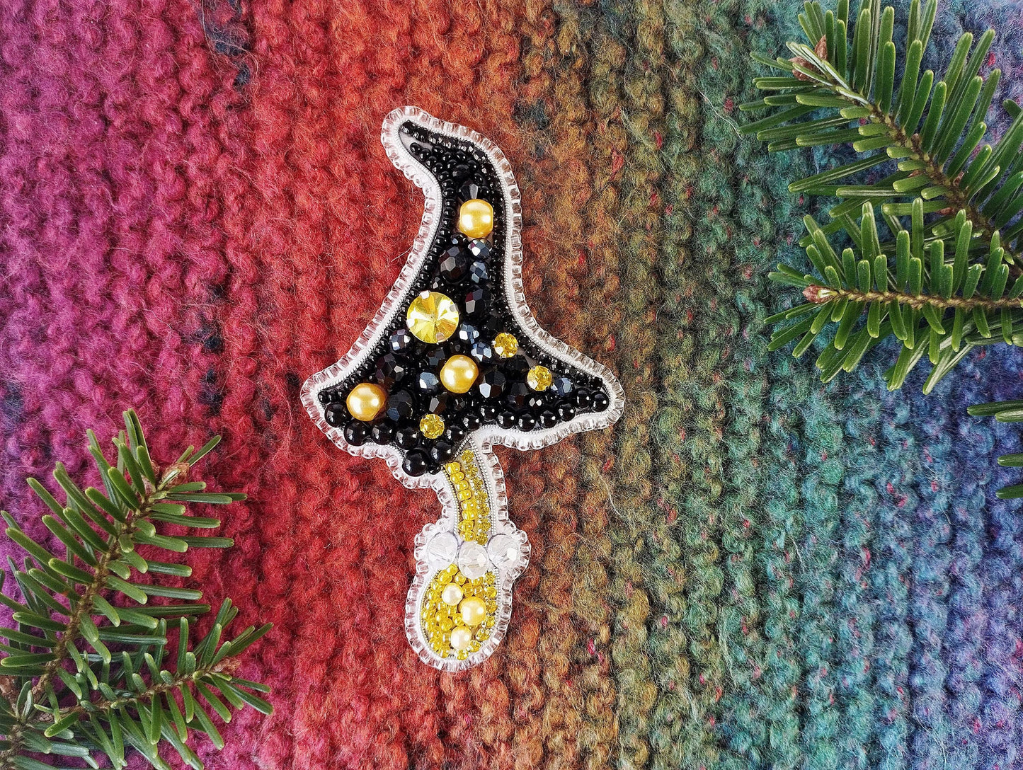 a knitted christmas ornament hanging from a tree branch