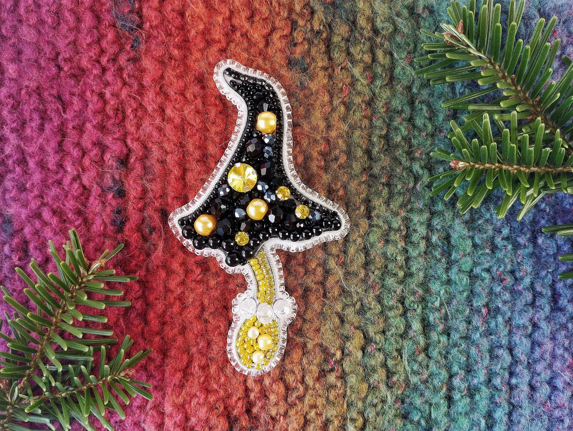 a knitted christmas ornament hanging from a tree branch