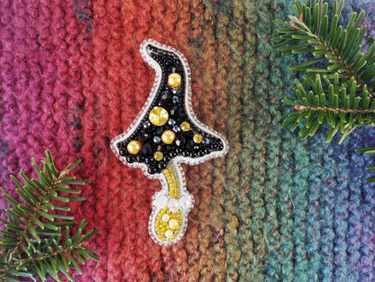 a knitted christmas ornament hanging from a tree branch