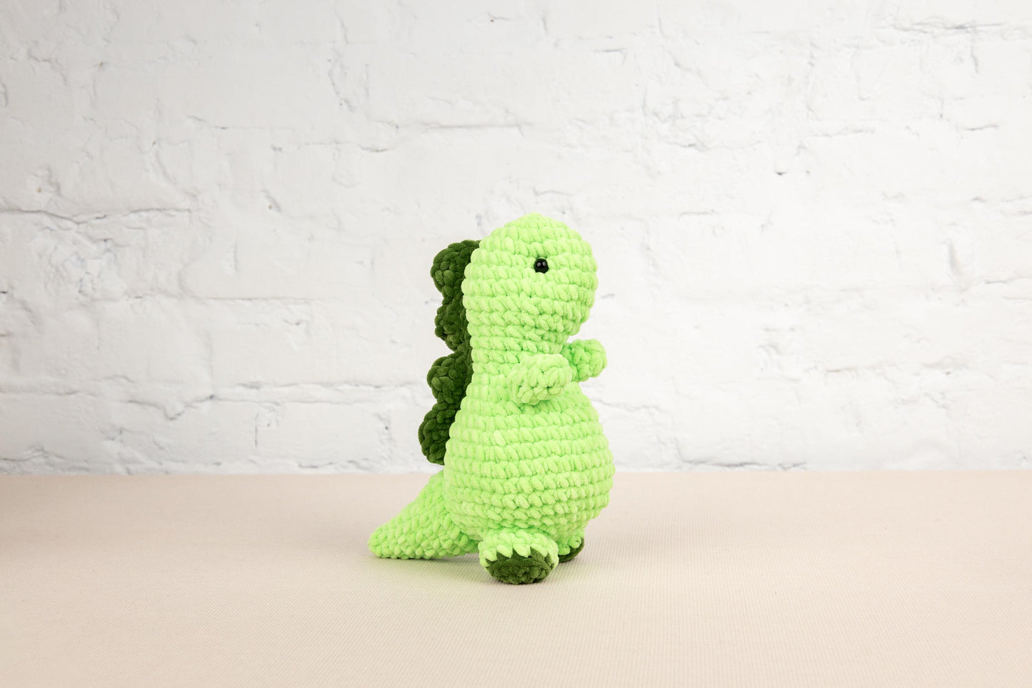 a green crocheted toy sitting on a table