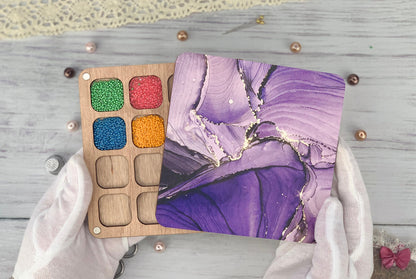 a person holding a wooden palette with a painting on it