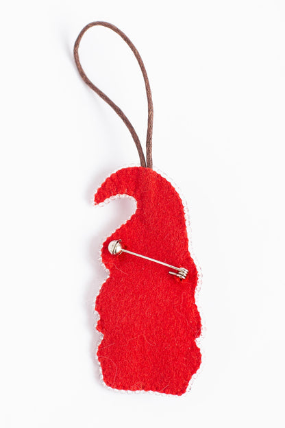 A red felt object resembling a gnome or elf, with a brown string or cord attached to it.