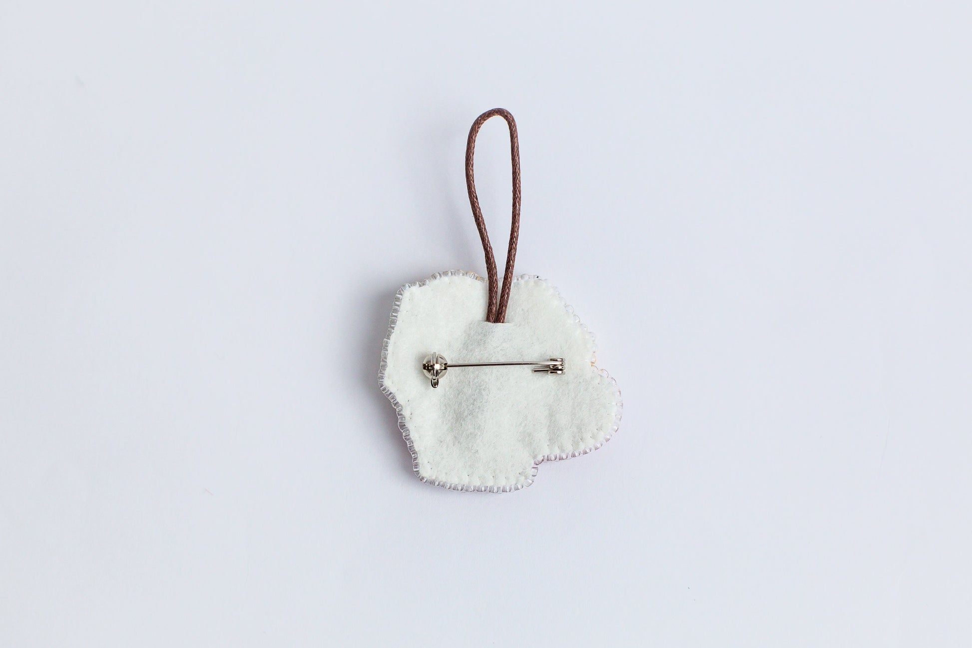 a white heart shaped ornament hanging from a cord