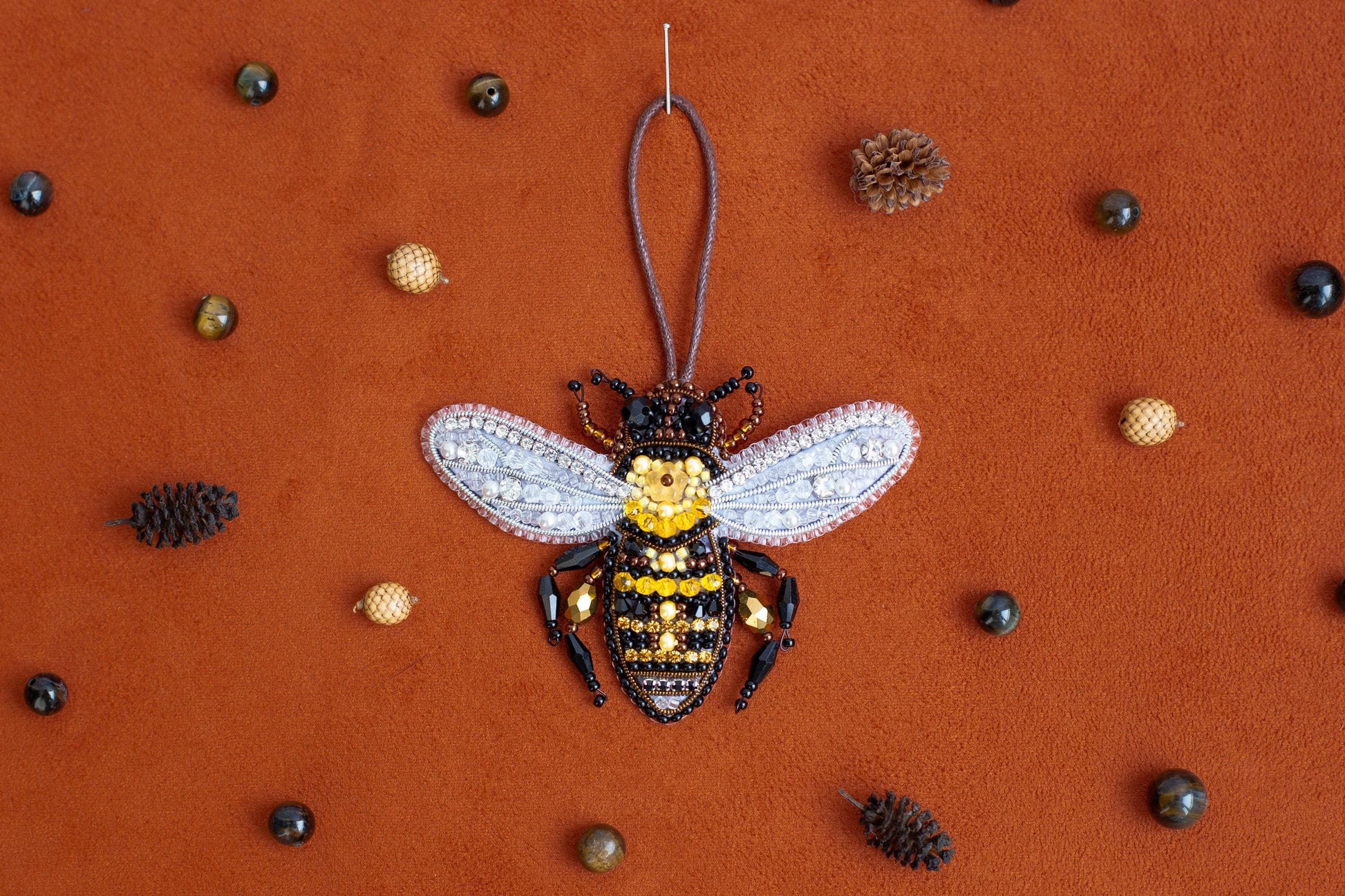 a beaded bee ornament hanging from a string
