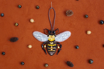 a beaded bee ornament hanging from a string