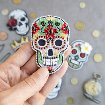 a person holding a small sugar skull in their hand
