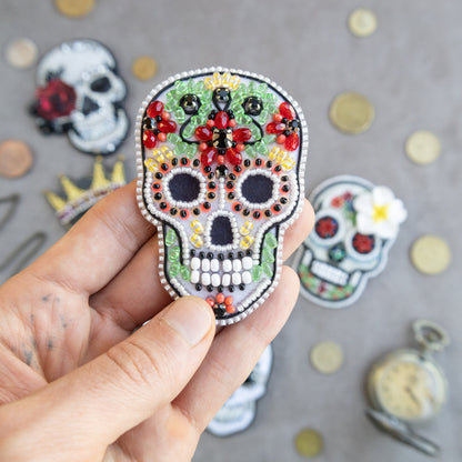 a person holding a small sugar skull in their hand
