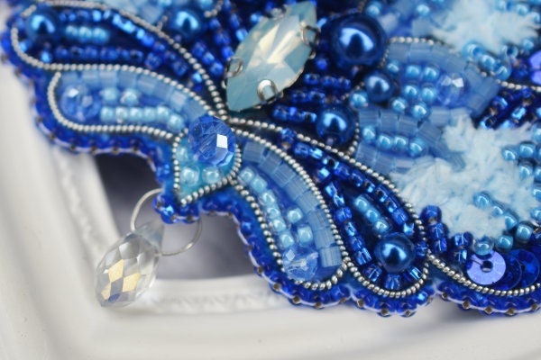 a close up of a blue beaded brooch