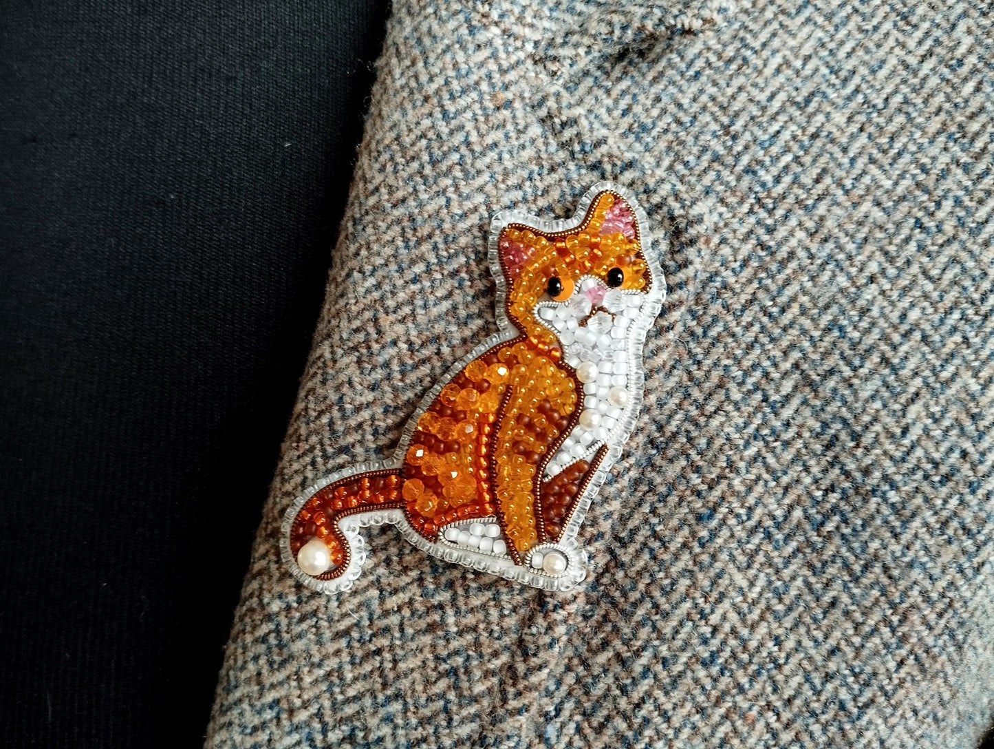 a close-up view of a cat embroidered on a fabric, with a detailed and intricate design.