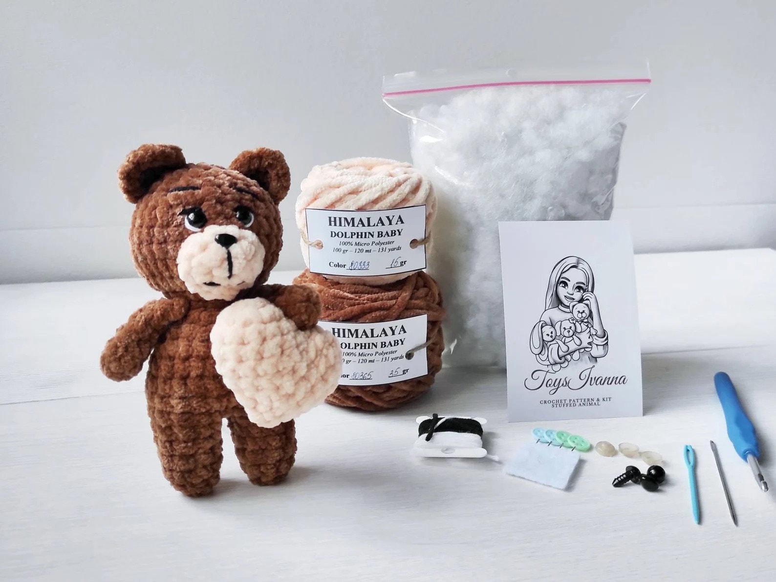 a crocheted teddy bear next to a bag of yarn