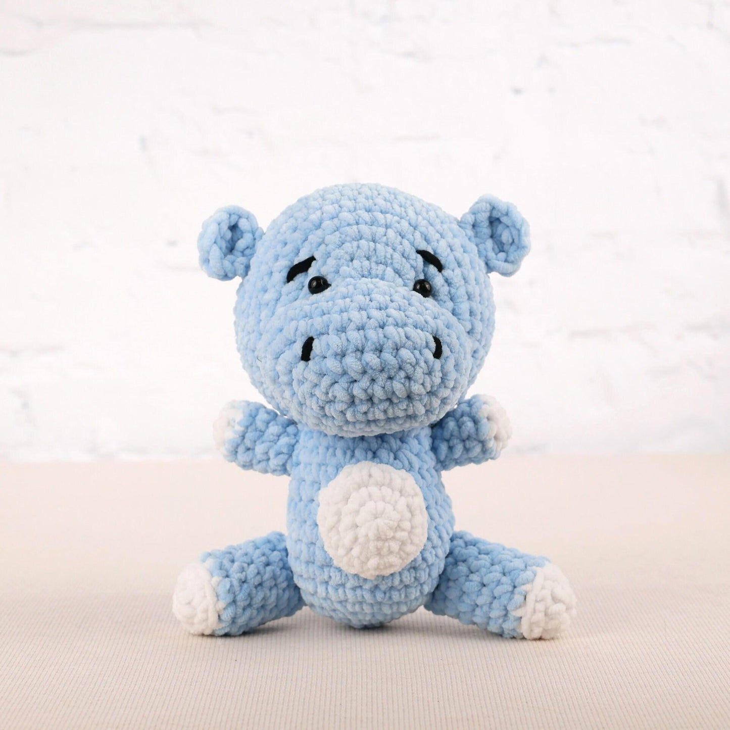 a blue crocheted stuffed animal sitting on a table