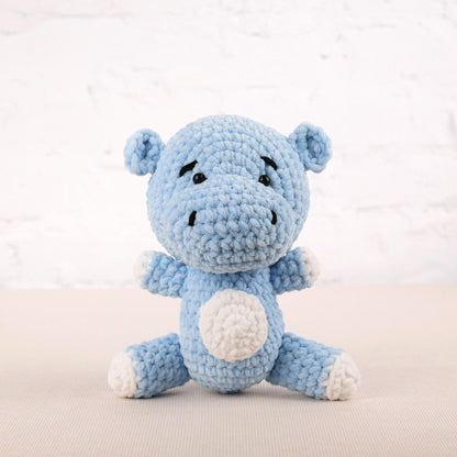 a blue crocheted stuffed animal sitting on a table