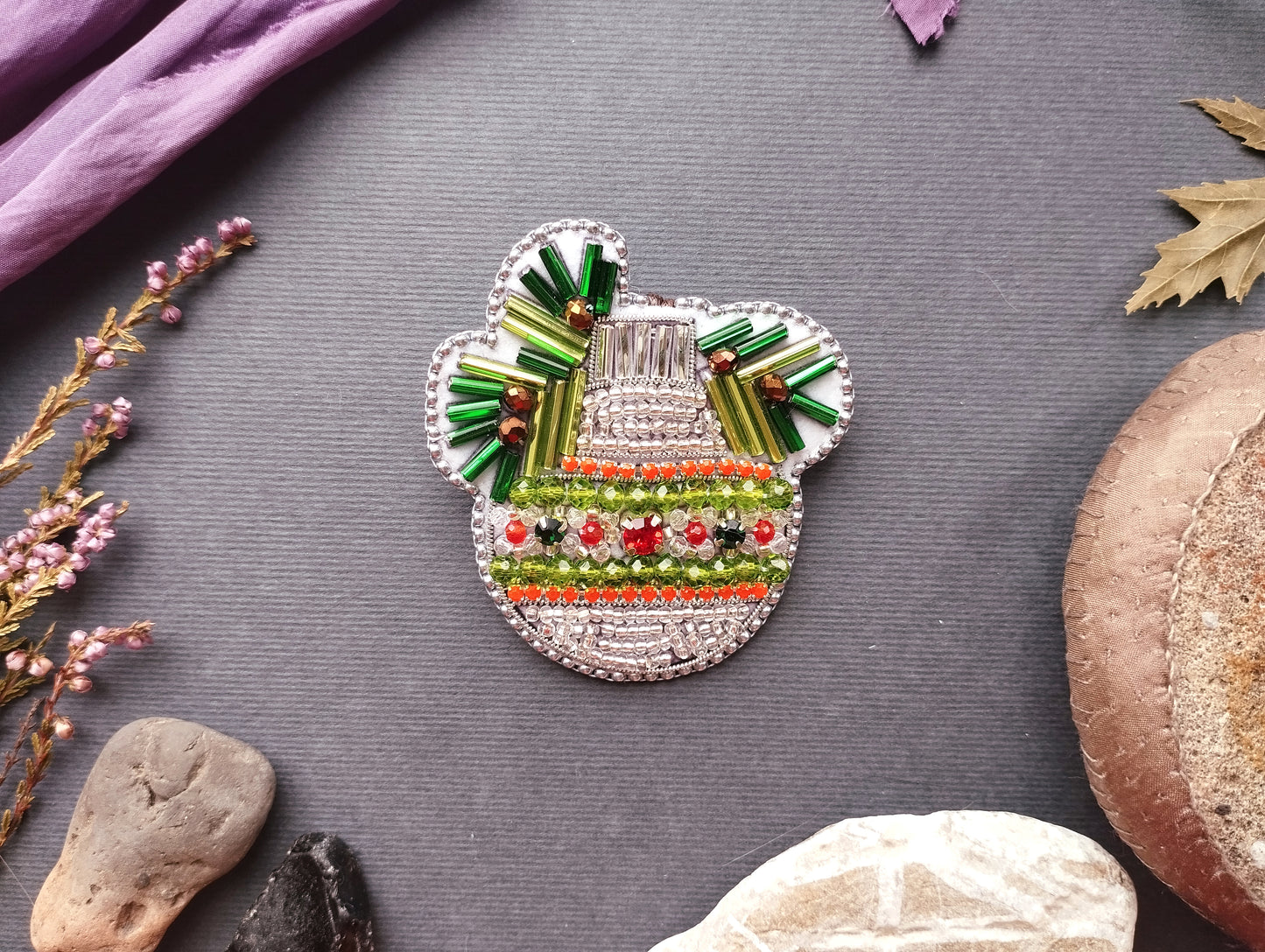 a decorative piece with a floral design, surrounded by various natural elements such as leaves, flowers, and rocks.