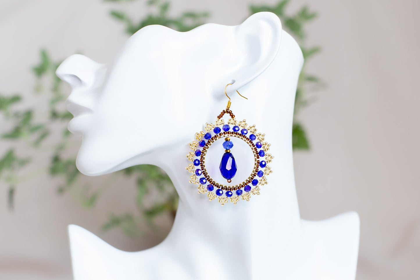 a close up of a pair of earrings on a mannequin head