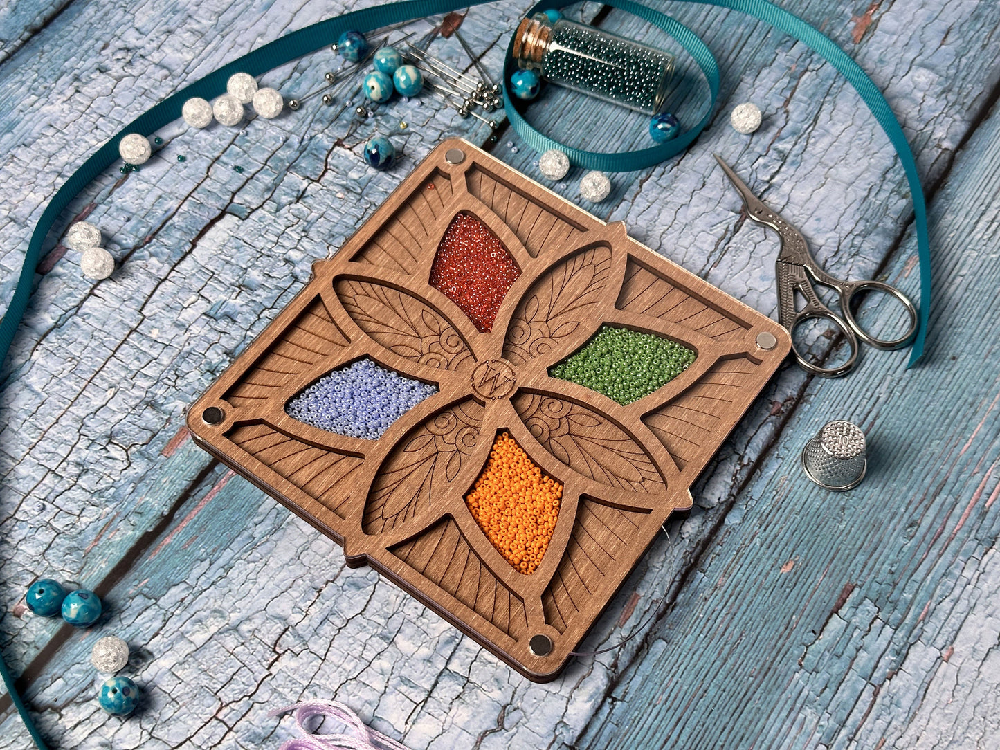 a wooden box with beads and a necklace on a table