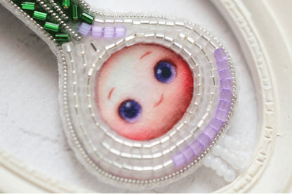 a close up of a brooch with a picture of a baby&#39;s face