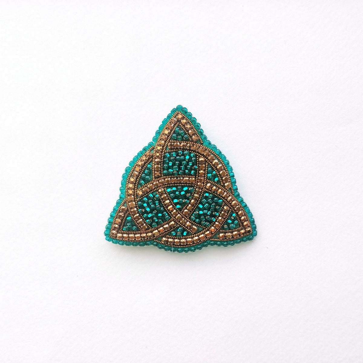 A triangular piece of jewelry with a beaded design, featuring a combination of blue and gold colors.