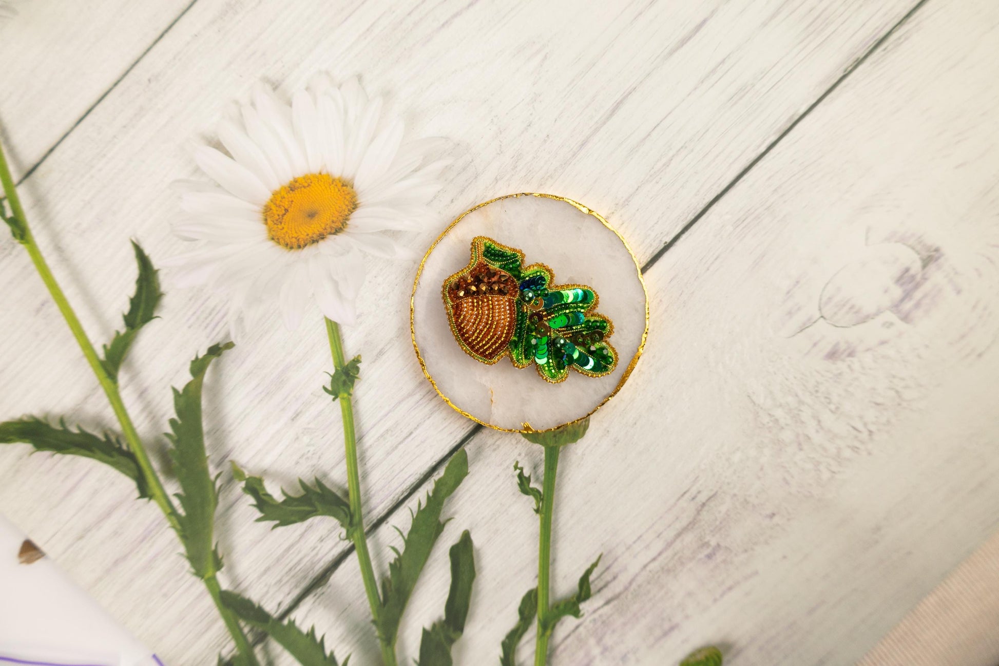a flower and a brooch sitting on a table