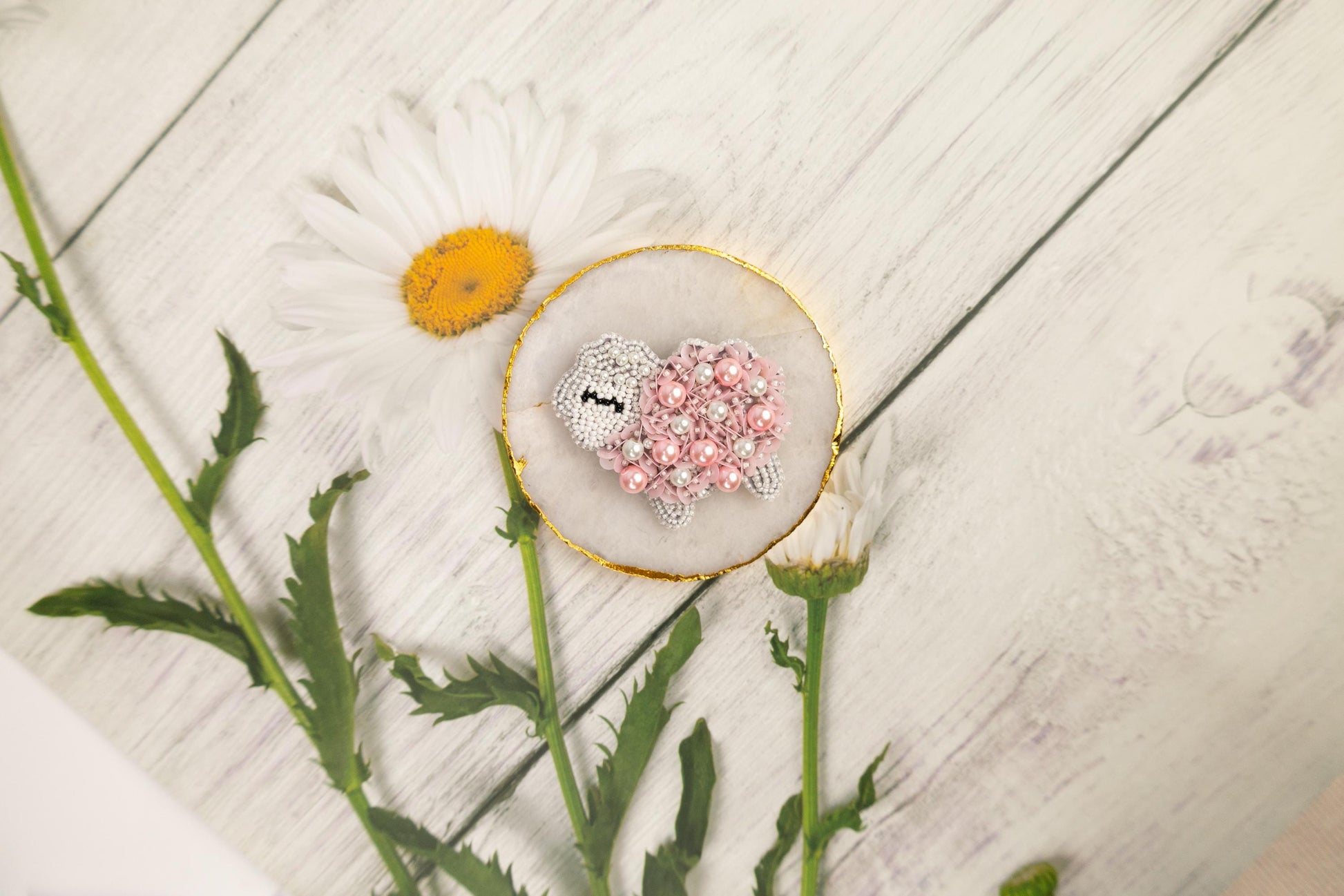 a daisy and two tiny hearts on a plate