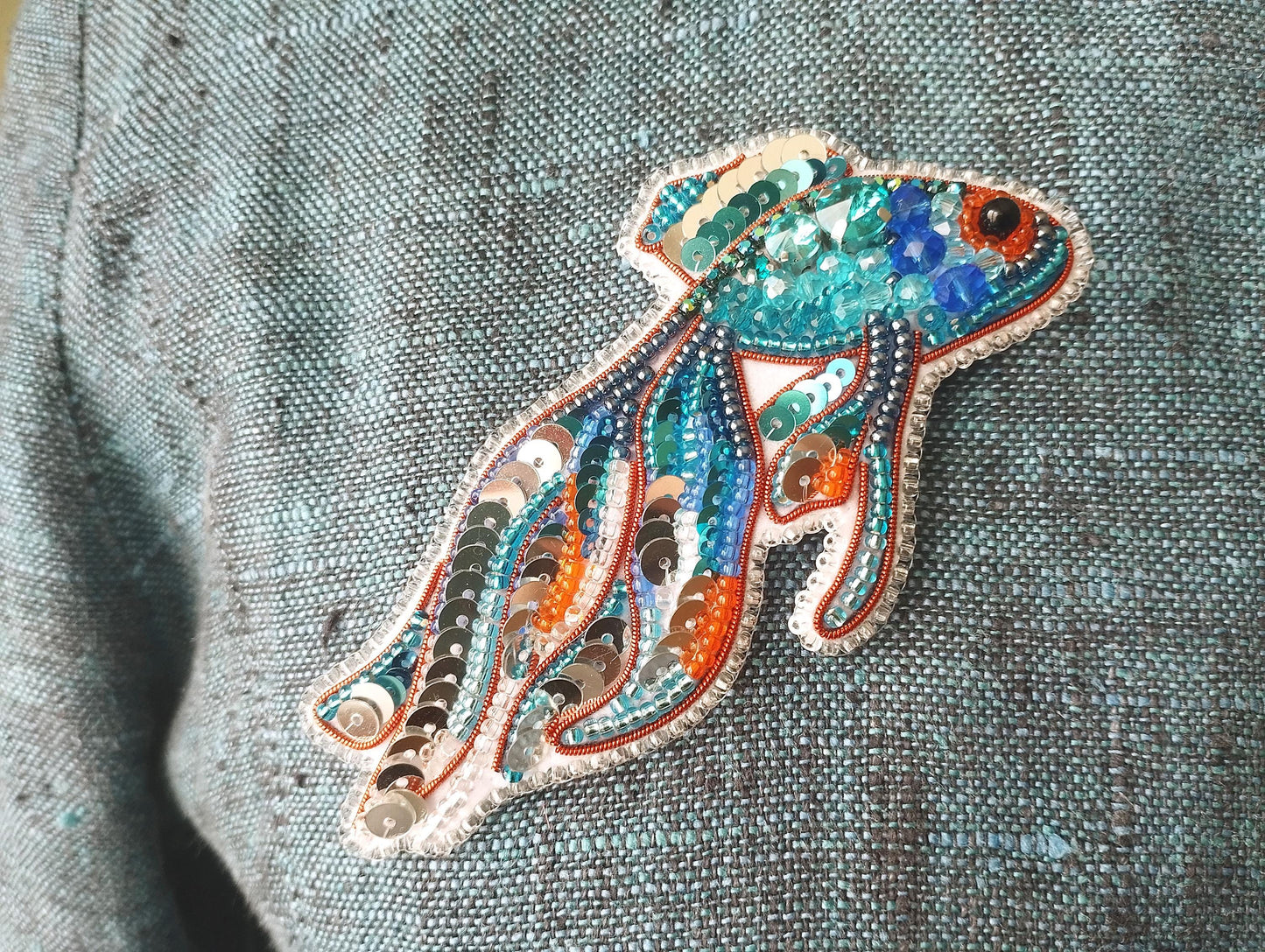 a close up of a person wearing a blue shirt with an orange and blue fish