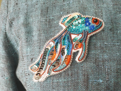 a close up of a person wearing a blue shirt with an orange and blue fish