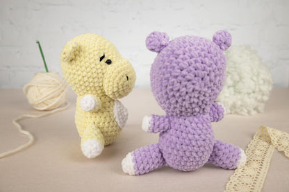 two crocheted stuffed animals sitting next to a ball of yarn