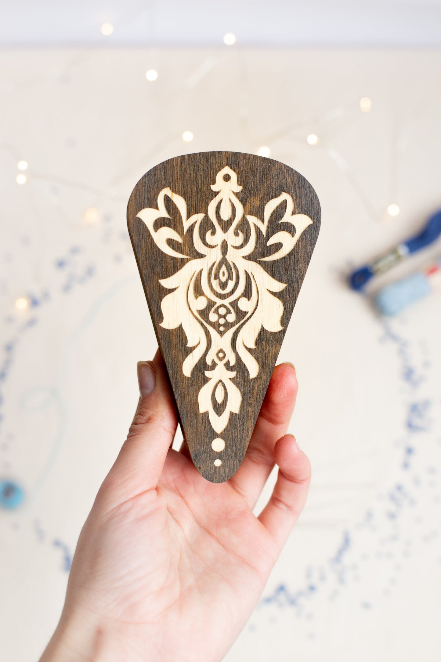 a person holding a wooden guitar pick in their hand