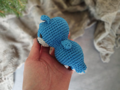 a hand holding a small crocheted stuffed animal