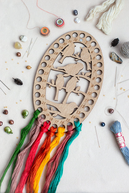 a wooden cutout of a deer surrounded by thread and beads
