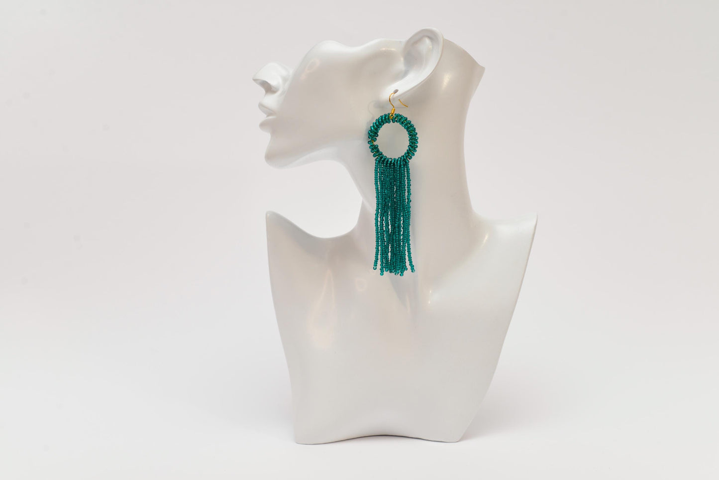 a white mannequin with a green tassel
