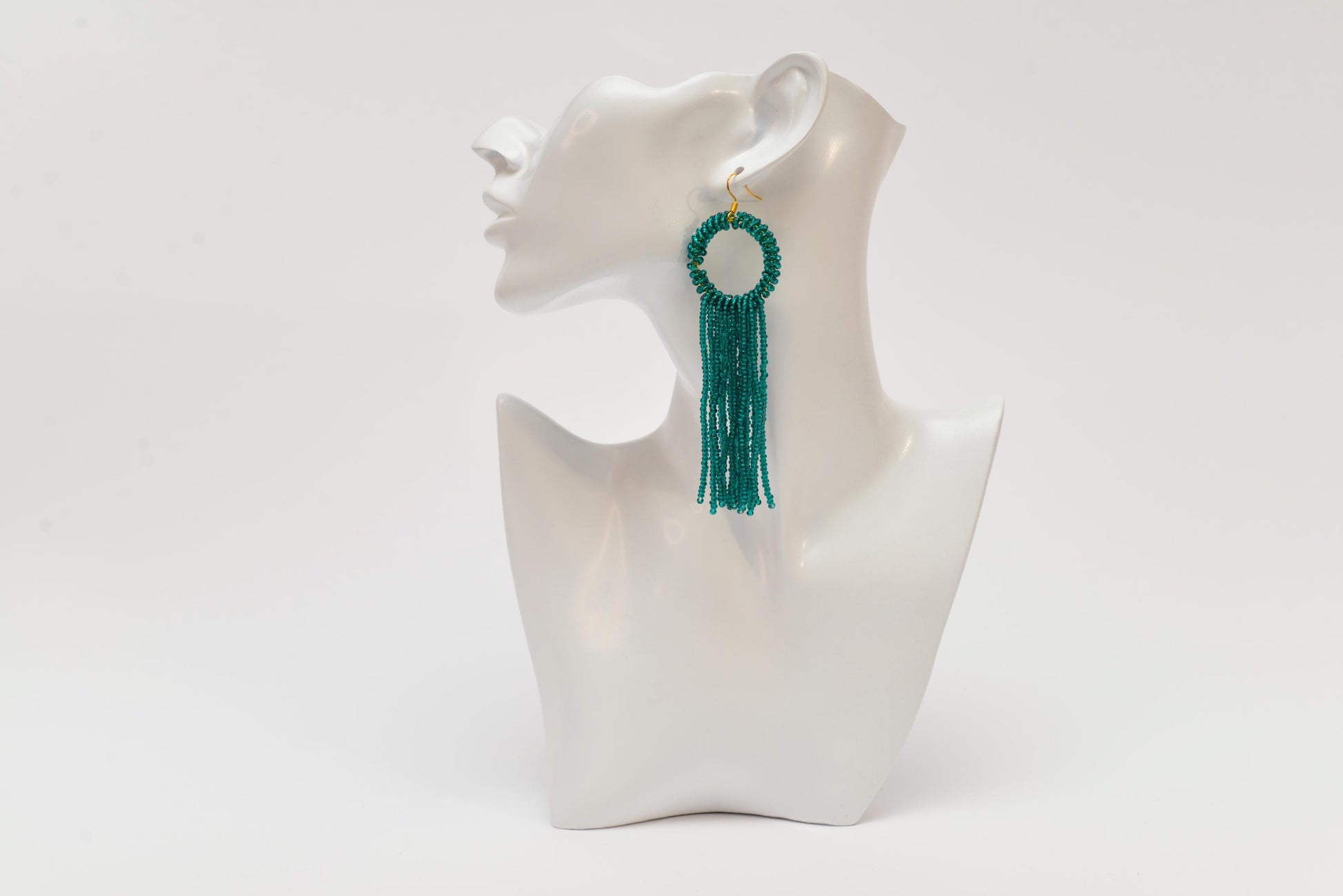 a white mannequin with a green tassel