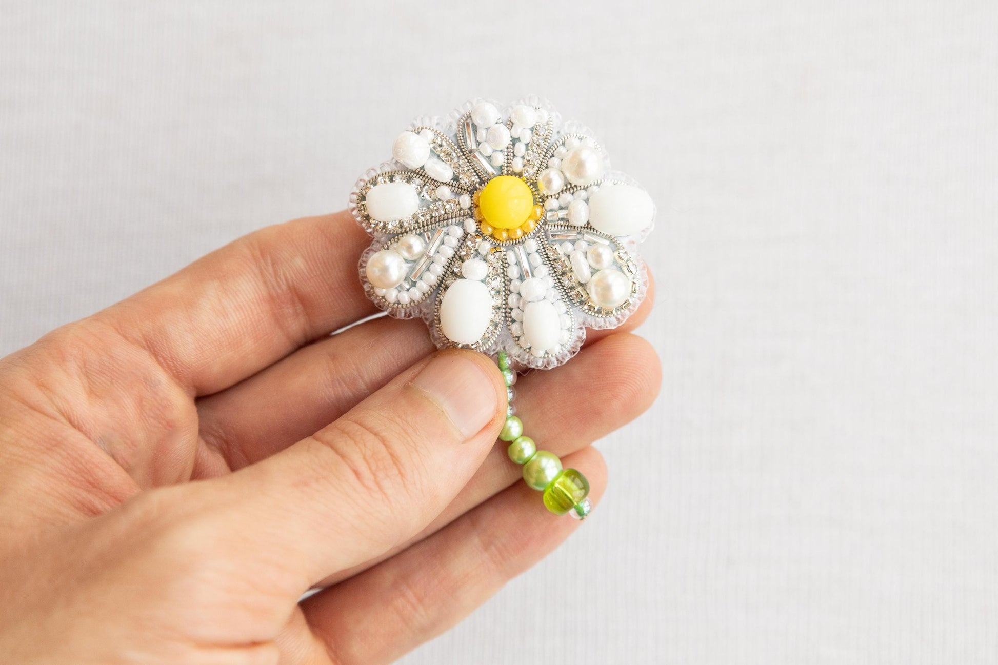 a person is holding a brooch in their hand
