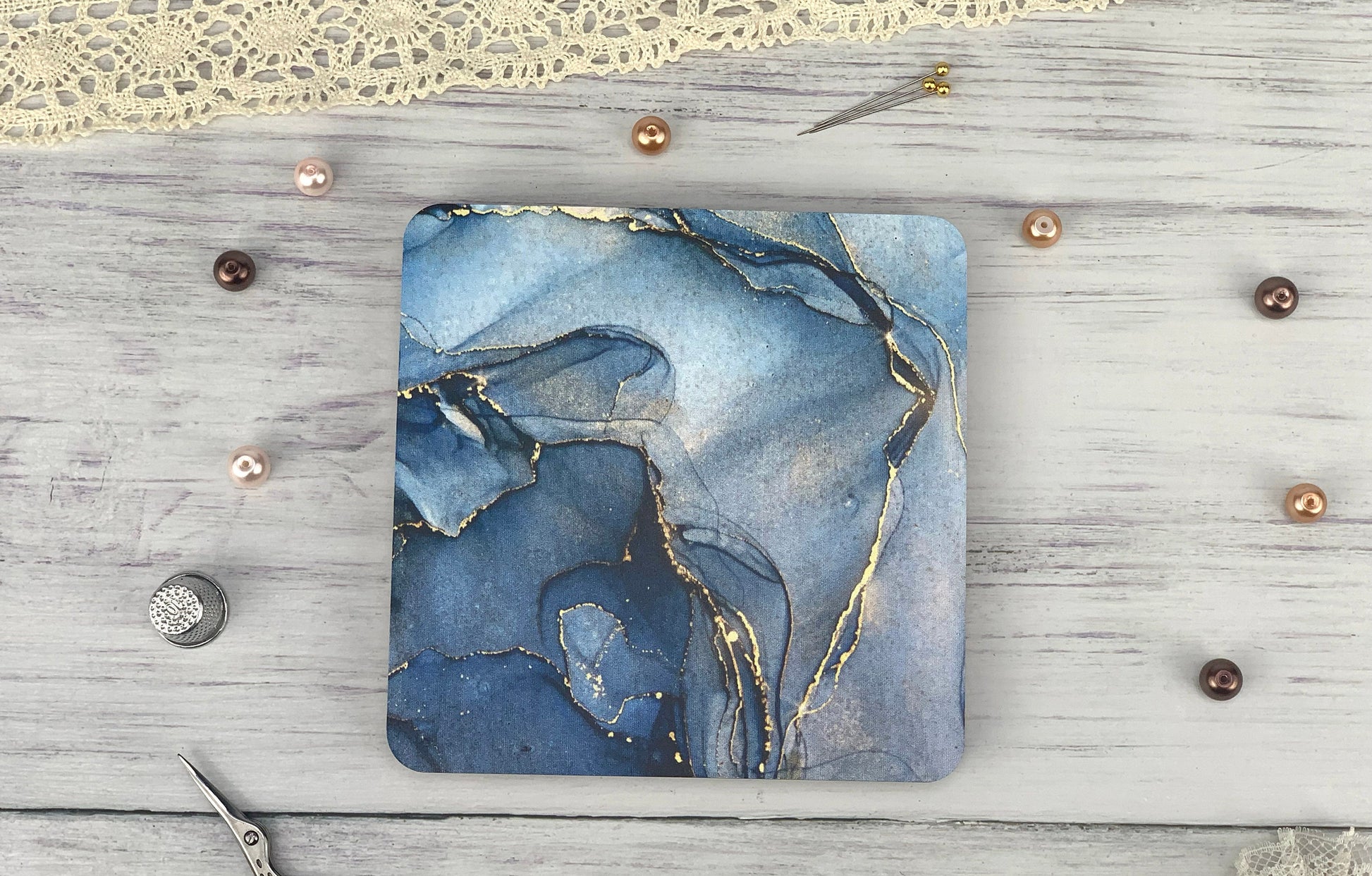 a square coaster with a blue and gold design